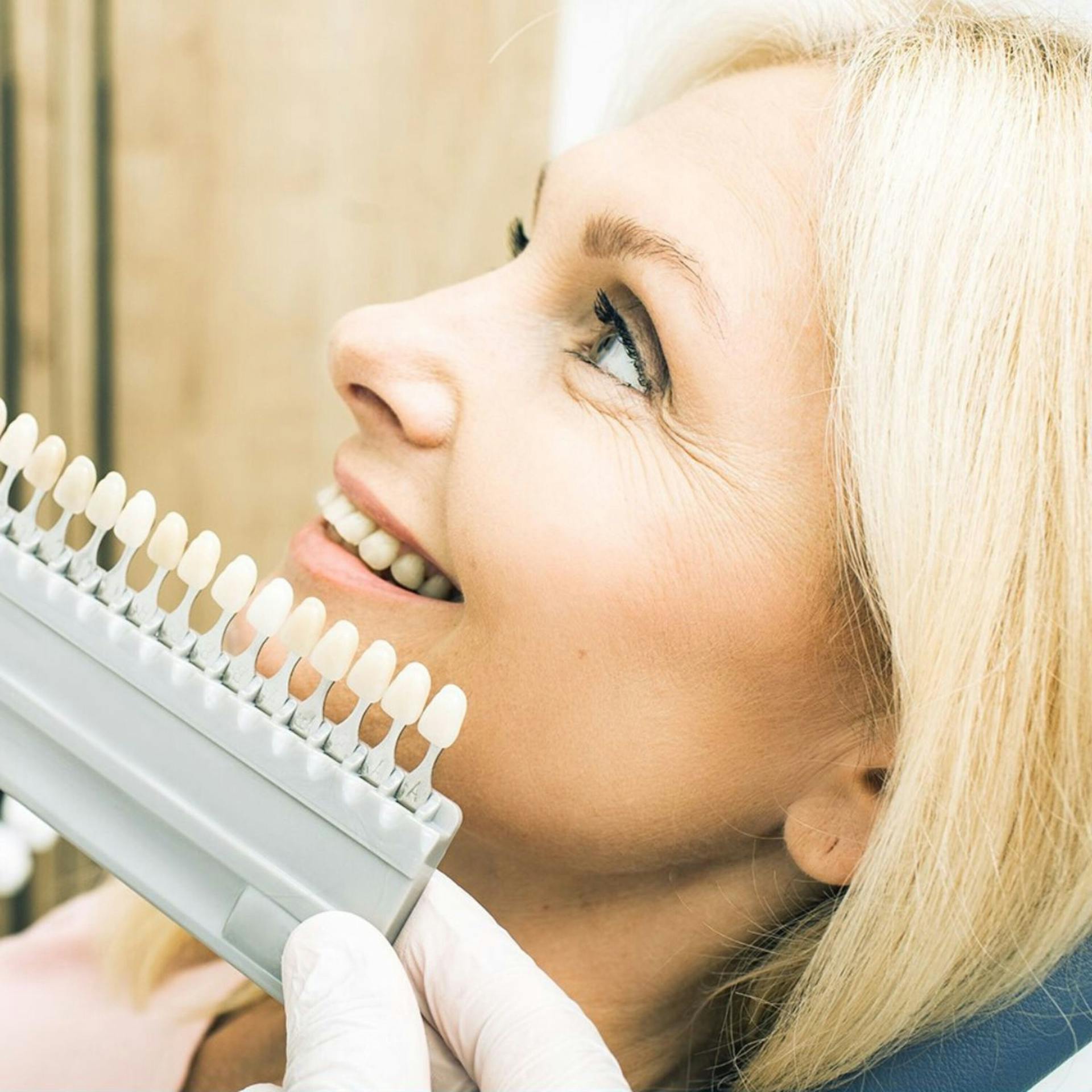 Woman selecting smile enamel shade in clinic