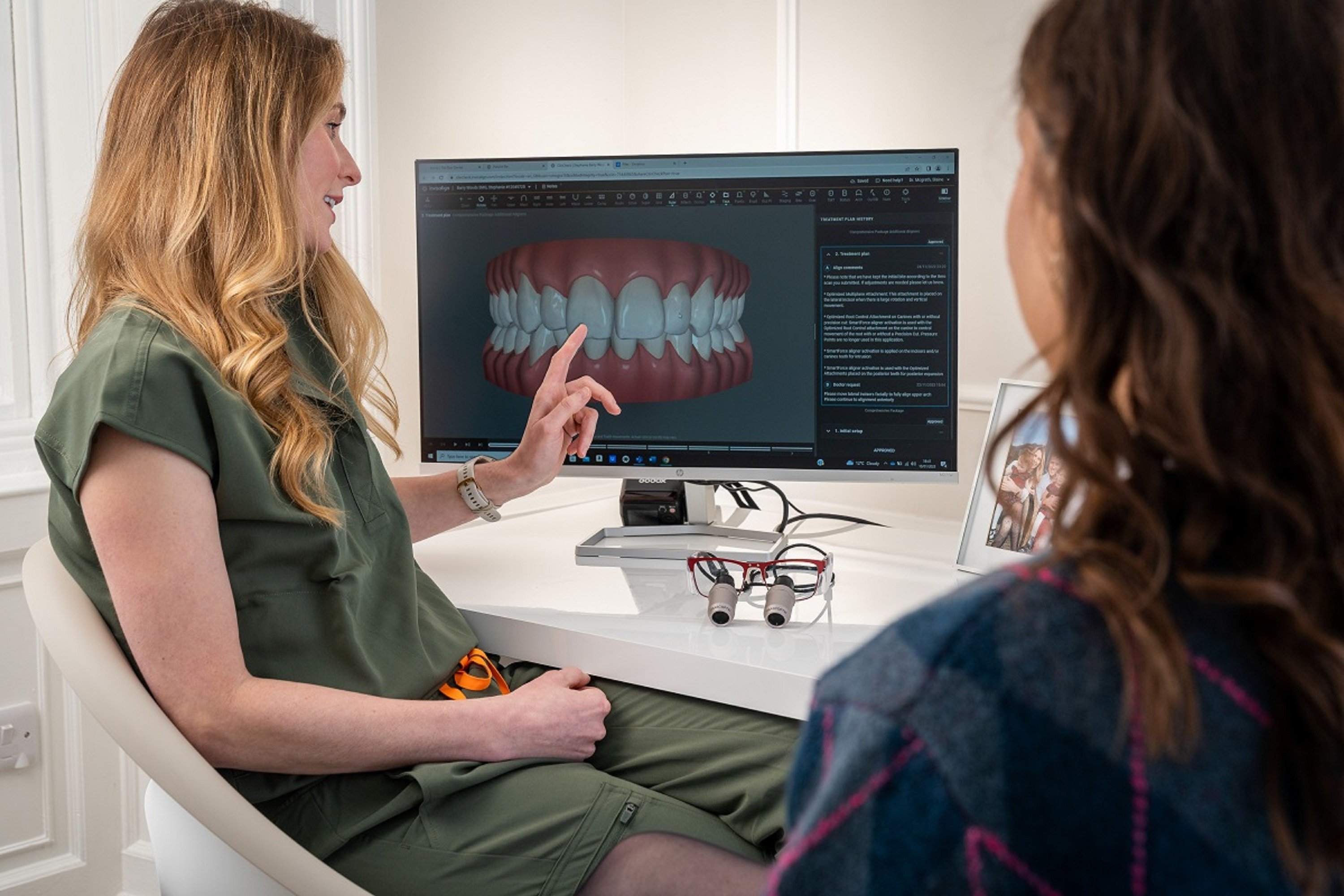 Dentist walking a patient through their digital treatment plan on screen